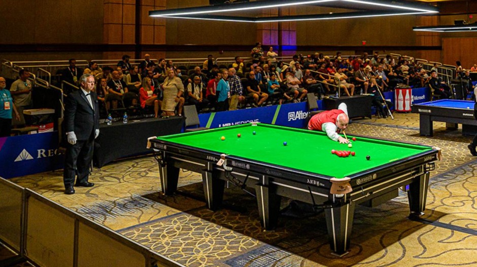 Darren Morgan pictured at the table during his quarterfinal match, as American referee John Lewis looks on attentively